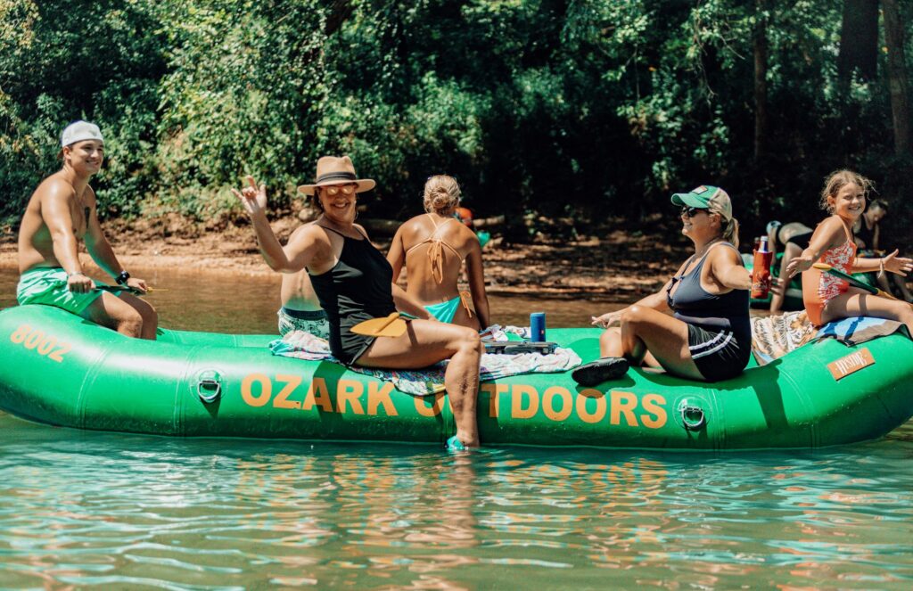 Group of friends floating the Meramec River in a green Ozark Outdoors raft