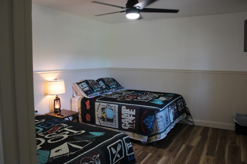 Lookout Lodge bedroom with two beds and a ceiling fan