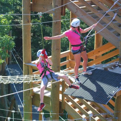 Floating-Treetops-Aerial-Park-Guide-Helping-Guest-400x400